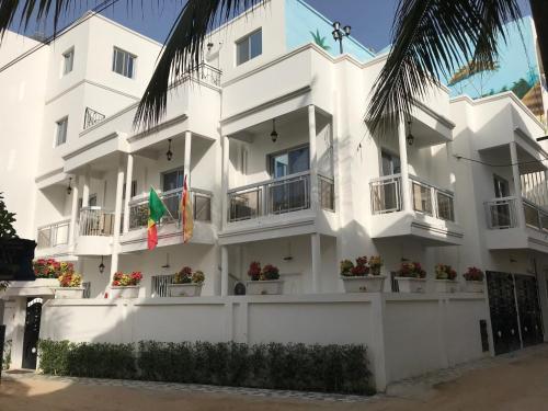 Un edificio blanco con plantas en macetas delante. en J PAD, en Dakar