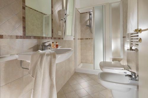 een badkamer met 2 wastafels en een toilet bij Hotel Ada in Rimini