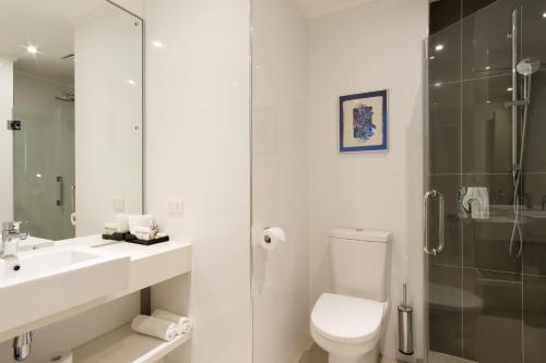 a bathroom with a toilet and a sink and a shower at Ramada Suites by Wyndham Wailoaloa Beach Fiji in Nadi