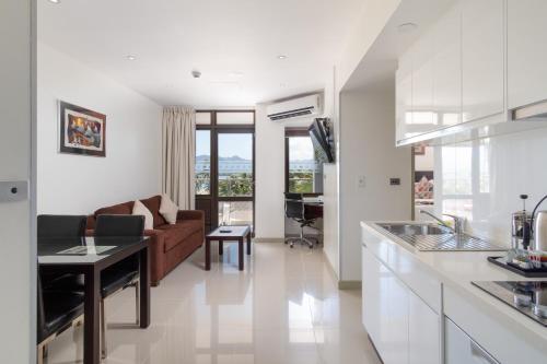 a kitchen and living room with a couch and a table at Ramada Suites by Wyndham Wailoaloa Beach Fiji in Nadi