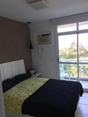 1 dormitorio con cama y ventana grande en Apartamento linda vista, 200 metros da praia de camboinhas en Niterói