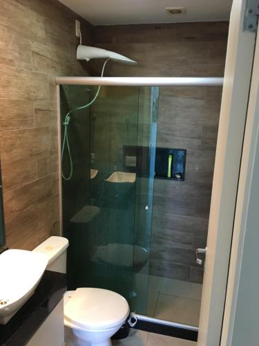 y baño con ducha de cristal y aseo. en Apartamento linda vista, 200 metros da praia de camboinhas en Niterói