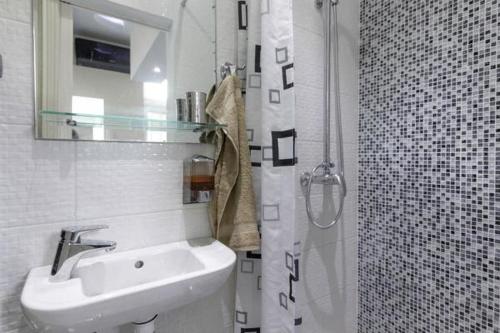 y baño blanco con lavabo y ducha. en Apartment Royal, en Belgrado