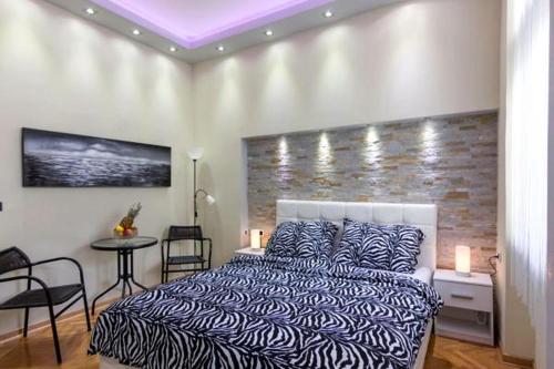 1 dormitorio con 1 cama y 1 mesa con sillas en Apartment Royal, en Belgrado