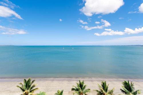 a view of a beach with palm trees and the ocean at Ramada Suites by Wyndham Wailoaloa Beach Fiji in Nadi