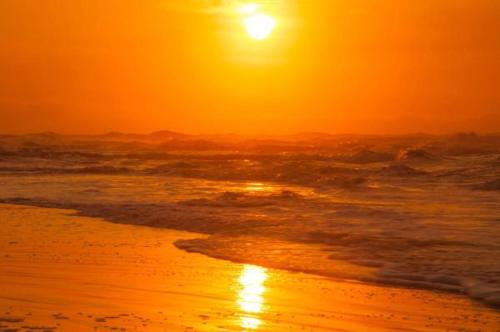a sunset on a beach with the ocean at Pousada Recanto Tropical in Ilha do Mel