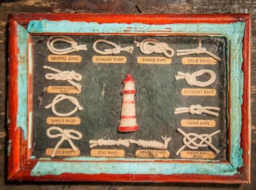 a picture of a board with a lighthouse and rope at Pousada Recanto Tropical in Ilha do Mel