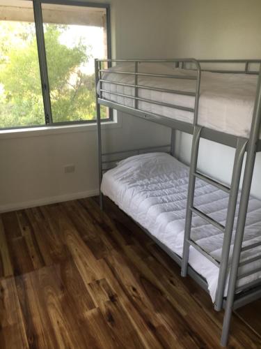Pokój z łóżkiem piętrowym z 2 łóżkami piętrowymi i oknem w obiekcie The Kite Beach House w mieście Guilderton