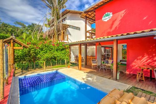 una casa con piscina y un edificio rojo en i9 Embaú Flats & Suites, en Itacaré