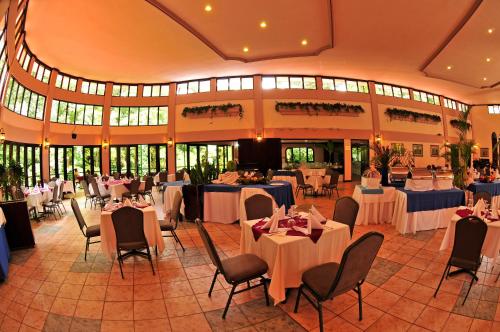 a banquet hall with tables and chairs in a building at El Tucano Resort & Thermal Spa in Quesada