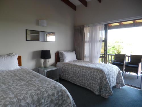 a hotel room with two beds and a balcony at Opua Boutique Seaview Motel in Opua