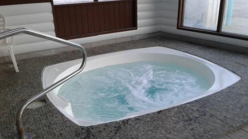a bath tub with water in it in a bathroom at Alpine Inn in Valemount