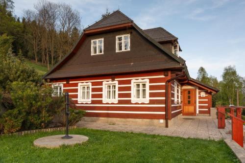 Dolní PolubnýにあるRoubenka Annaの黒屋根の小さな木造家屋