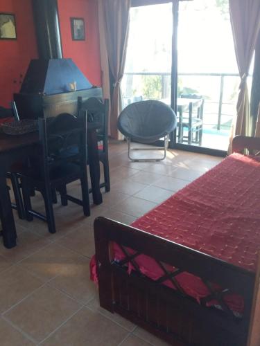 a bedroom with a piano and a chair and a bed at Visión ESCAPE Piriápolis in Piriápolis