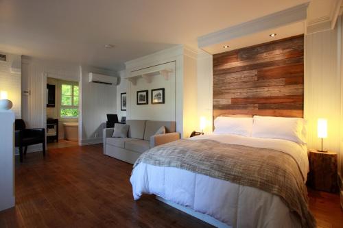 - une chambre avec un grand lit et un salon dans l'établissement Village Historique de Val-Jalbert, à Chambord