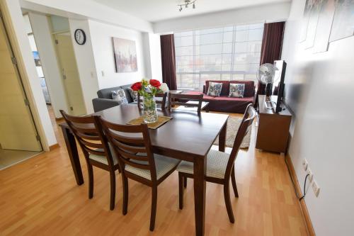 a dining room and living room with a table and chairs at Miraflores4Rent Alcanfores in Lima