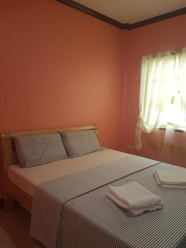 a bedroom with a bed with two towels on it at Stella'z guesthouse in Siquijor
