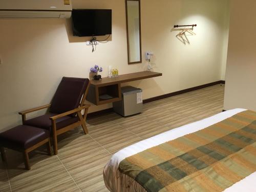 una camera d'albergo con un letto, una sedia e una scrivania di Baan Wanchart a Bangkok