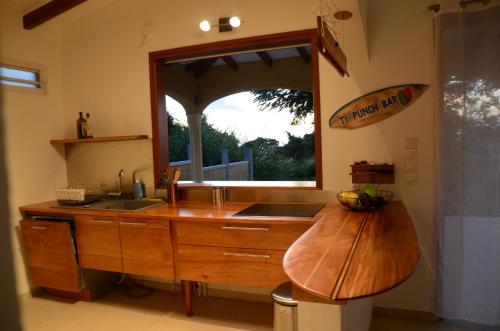 a kitchen with a wooden counter top and a window at villa stenella in Bouillante