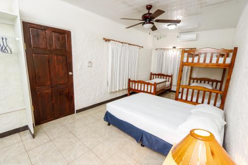 a bedroom with a bed and a ceiling fan at Hotel Flor Blanca in Manuel Antonio