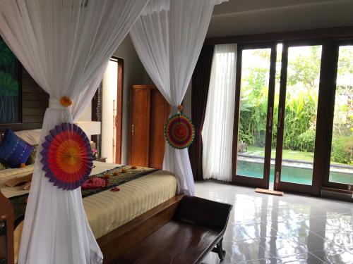 a bedroom with a bed with white drapes at Ubud Paradise Villa in Ubud