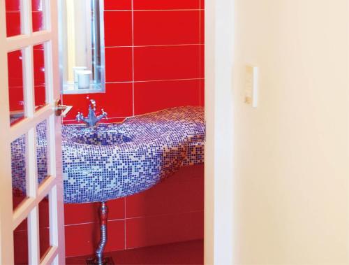 a bathroom with a sink and a red wall at Haslla Art World Museum Hotel in Gangneung