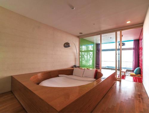 a bedroom with a bed with a wooden bed frame at Haslla Art World Museum Hotel in Gangneung