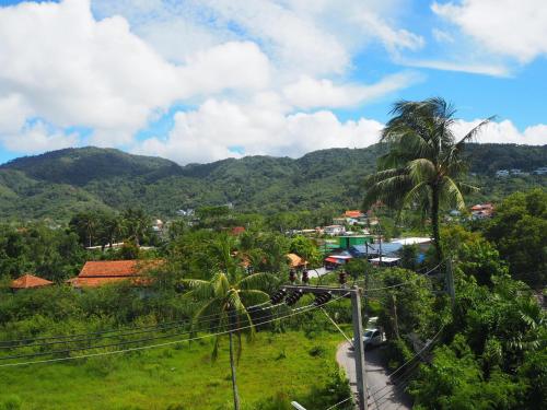 a town on a hill with a palm tree and a road at Baan Rosa Bangtao Beach in Bang Tao Beach