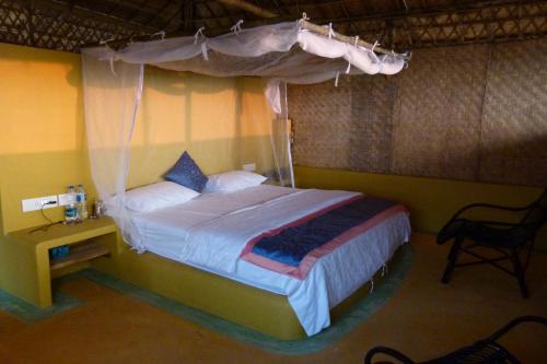 a bedroom with a bed with a canopy at Beach Street Eco Resort - Mandrem in Mandrem