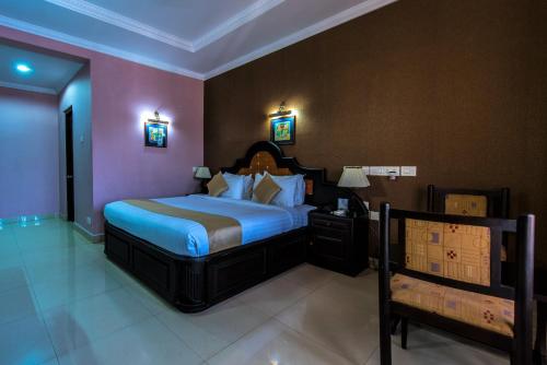 a bedroom with a large bed with a blue comforter at Kallada Regency in Irinjālakuda