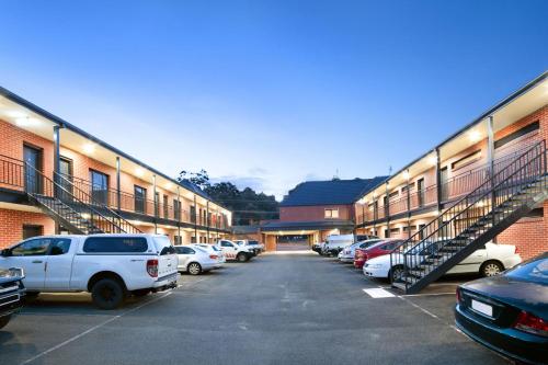 a parking lot with cars parked in front of a building at Ballarat Suites in Ballarat