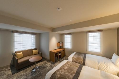 a hotel room with two beds and a couch at Kyoto Gion U-BELL Hotel in Kyoto