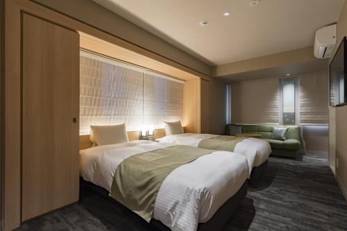 a hotel room with two beds and a couch at Kyoto Gion U-BELL Hotel in Kyoto