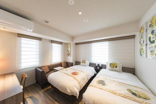 two beds in a room with windows at Kyoto Gion U-BELL Hotel in Kyoto