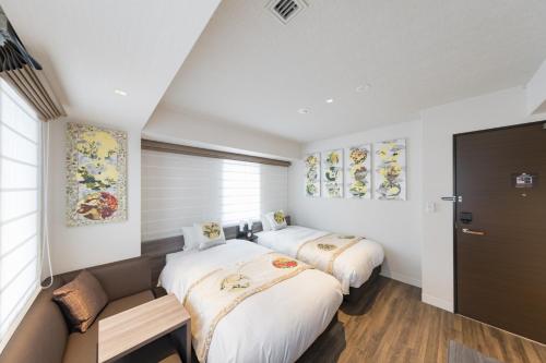 a bedroom with two beds and a couch at Kyoto Gion U-BELL Hotel in Kyoto