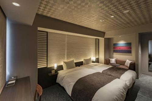 a bedroom with a large bed and a window at Kyoto Gion U-BELL Hotel in Kyoto