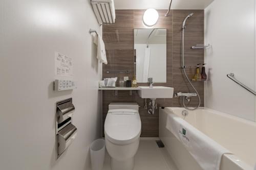 a bathroom with a toilet and a sink and a tub at Kyoto Gion U-BELL Hotel in Kyoto