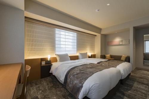 a bedroom with a large bed and a window at Kyoto Gion U-BELL Hotel in Kyoto