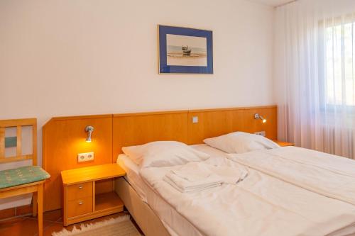 DewichowにあるApartment Naturgenussのベッドルーム(大きな白いベッド1台、テーブル付)
