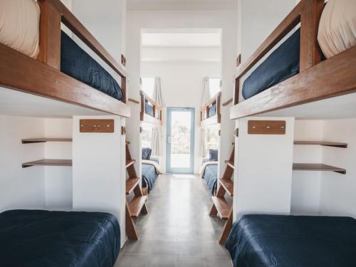 een kamer met 2 bedden en een hal met planken bij Kos One Hostel in Canggu