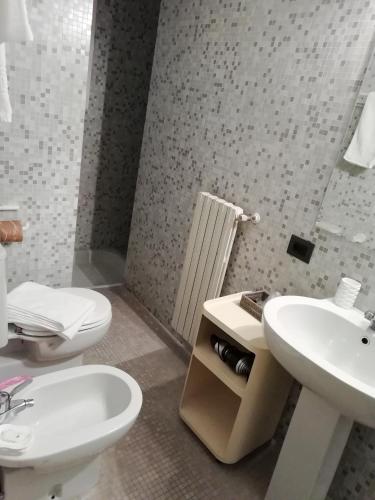 a bathroom with a white toilet and a sink at B&b Pergola House in Lucca