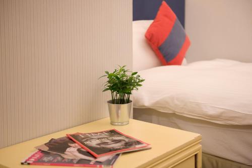 a table with a potted plant on it next to a bed at Elizabeth Hotel in Taichung