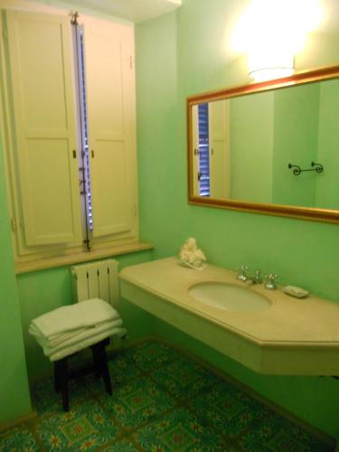 a bathroom with a sink and a mirror and a stool at Locanda di Porta Antica in San Benedetto del Tronto