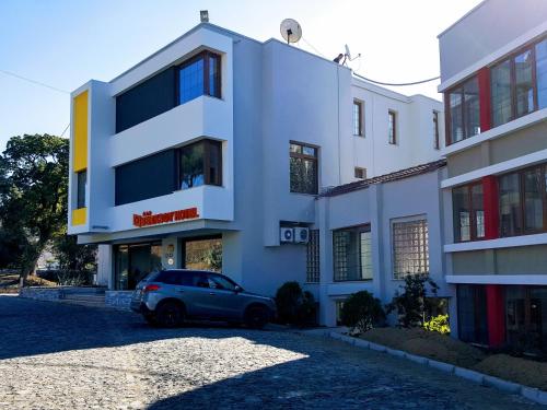 a car parked in front of a white building at Berksoy Hotel in Bergama