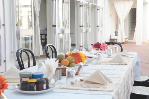 a long table with white table cloth and fruit on it at Savista Retreat in Jaipur