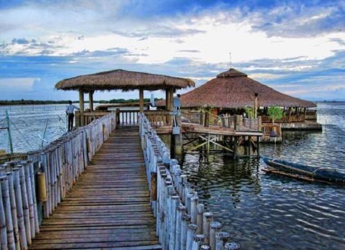 uma doca de madeira com dois guarda-sóis e um cais com um cais em Haus of Emerald by JeYo em Mactan