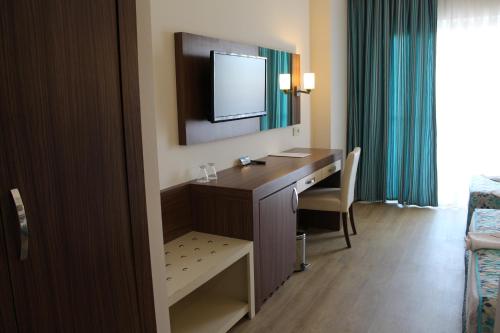 a hotel room with a desk and a mirror at Side West Park Hotel in Side