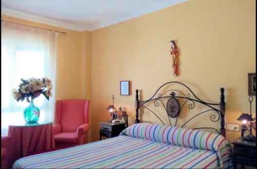 エル・プエルト・デ・サンタマリアにあるApartamento con vistas a la Bahía.のベッドルーム1室(ベッド1台、ピンクの椅子付)