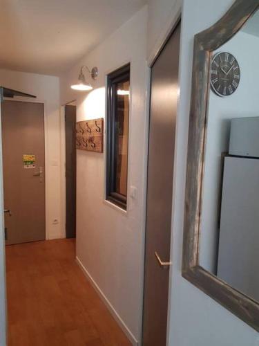 un couloir avec une porte et une horloge sur un mur dans l'établissement Appartement Flocon, 2 chambres, à Saint-Sorlin-dʼArves
