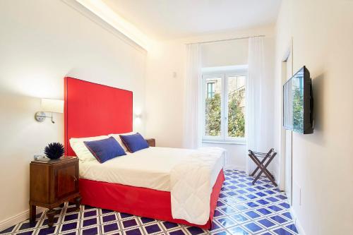 a bedroom with a red and white bed and a tv at Palazzo Gentilcore in Castellabate